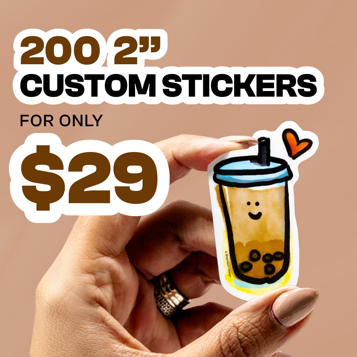 Square promotional image with warm tan background featuring bold white and brown text reading 200 2 inch custom stickers for only $29. In the foreground, a hand with neutral nail polish holds a small die cut sticker of a smiling bubble tea cup with black tapioca pearls, blue lid, straw, and orange heart accent.