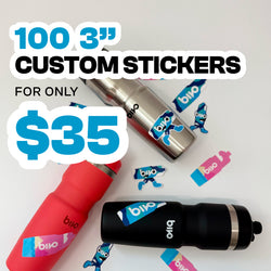 Square promotional image featuring stainless steel, coral red, and matte black Bivo reusable water bottles arranged on a white background with colorful custom vinyl stickers applied and scattered around. Large white and blue text reads 100 3 inch custom stickers for only $35. Stickers display bold blue, teal, and pink Bivo branding graphics.