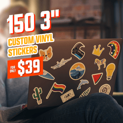 Image of a laptop covered in colorful vinyl stickers including animals, shapes, travel motifs, and rainbow striped designs. Text in white, orange, and red reads 150 3 inch custom vinyl stickers for only 39. Warm indoor setting with blurred background and cozy lighting.