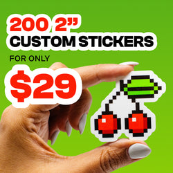 Hand holding a die cut custom vinyl sticker featuring a pixel style cherry design with red cherries and a green stem against a bright green background. Promotional text reads 200 2 inch custom stickers for only 29 dollars in bold black and red lettering