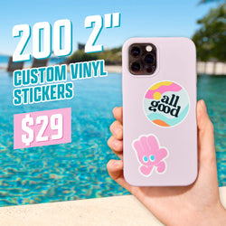 Promo graphic featuring a hand holding a phone with colorful vinyl stickers on the back, including a circular “all good” sticker and a pink hand character. Large text reads “200 2'' Custom Vinyl Stickers $29.” Background shows an outdoor poolside scene with bright aqua water.