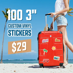 Red suitcase covered in travel-themed die-cut stickers including Aloha, a palm tree, a sun icon, a city landmark, and a London bus, set on a tropical beach with palm trees and blue sky. On-image text reads 100 3 inch custom vinyl stickers for $29. Ideal for travel stickers, luggage decals, and waterproof vacation stickers.