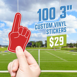 Hand holding a die-cut red foam finger sticker pointing upward inside a bright football stadium scene with goalposts. On-image text reads 100 3 inch custom vinyl stickers for $29. Keywords: sports stickers, foam finger decals, game day vinyl stickers.