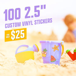 Colorful beach toys decorated with cute die-cut stickers including a pineapple with heart-shaped sunglasses, a starfish cartoon, and a smiling watermelon slice. Art style uses cheerful pastel colors and thick outlines for a kid-friendly, playful aesthetic. Sandy beach background with soft sunlight. On-image text reads 100 2.5 inch custom vinyl stickers and 25. Keywords: kids beach stickers, cute summer decals, playful vinyl sticker art.