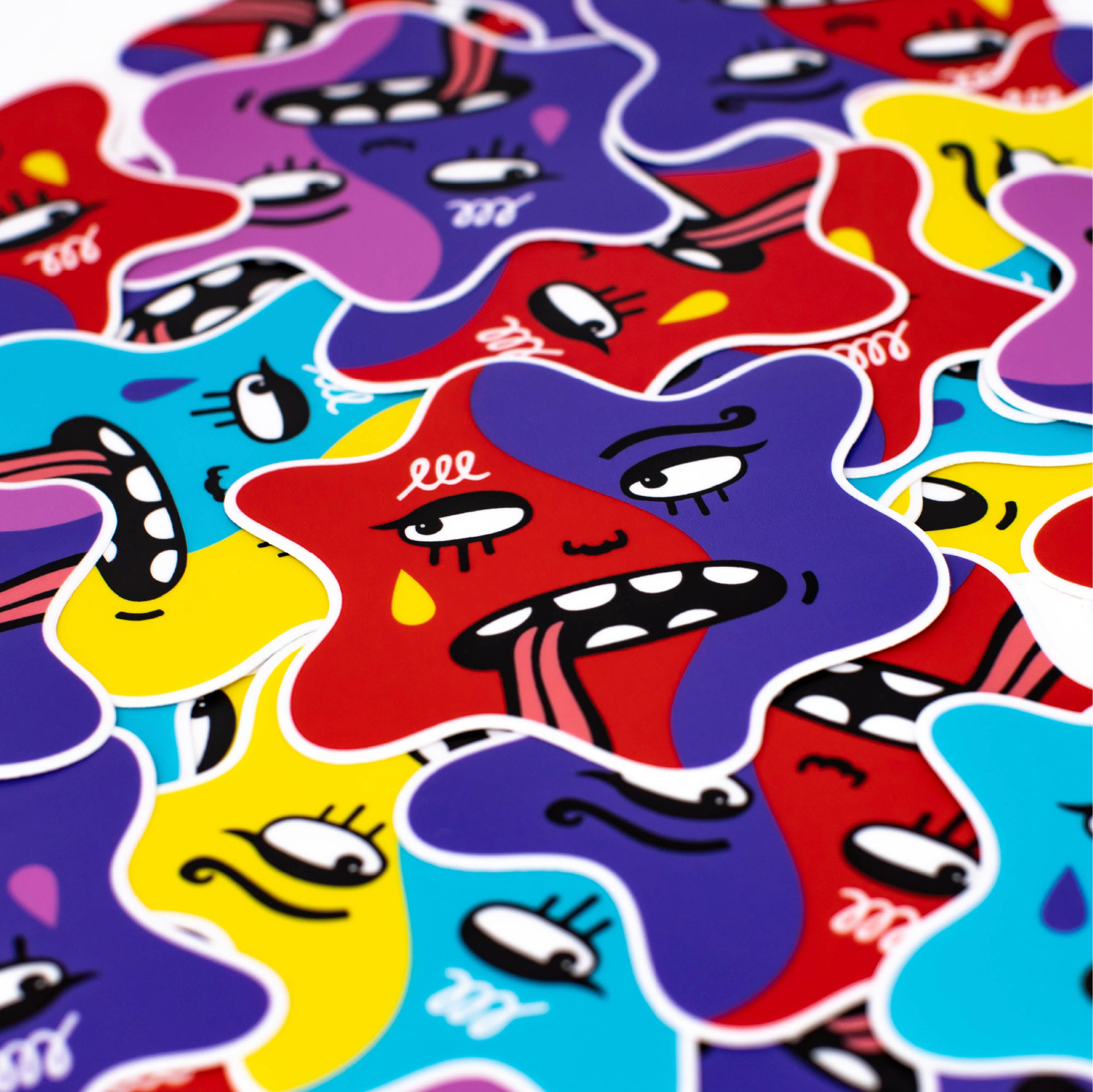 A close-up of colorful star-shaped stickers with cartoon faces in red, purple, blue, yellow, and pink, overlapping on a white background.