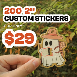 'Promotional graphic advertising 200 custom 2-inch stickers for only $29. Bold orange, black, and white text appears over a leafy green outdoor background. A hand holds a die-cut sticker featuring a cute white ghost wearing a tan hiking hat and backpack, holding a walking stick and a map labeled 'STUDY'.'