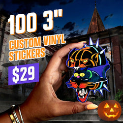 Hand holding a bold tattoo-inspired die-cut sticker featuring a snarling tiger head stacked above a black panther head and a stylized cat, surrounded by blue spikes. Halloween-themed background with jack-o-lantern. On-image text reads 100 3 inch custom vinyl stickers for $29. Strong keywords include tattoo stickers, tiger stickers, panther decals, and bold aesthetic vinyl designs.
