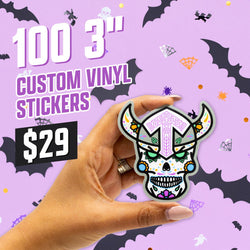 Hand holding a die-cut sugar skull sticker illustrated in a bold neo-folk style with Viking horns, geometric lavender markings, green leaf motifs, and vibrant dot details. The background features a pastel purple Halloween theme with flying bats, spiders, cobwebs, and scattered confetti. On-image text reads 100 3 inch custom vinyl stickers and 29. Keywords: sugar skull sticker, Viking skull art, decorative vinyl decal, aesthetic die-cut sticker.