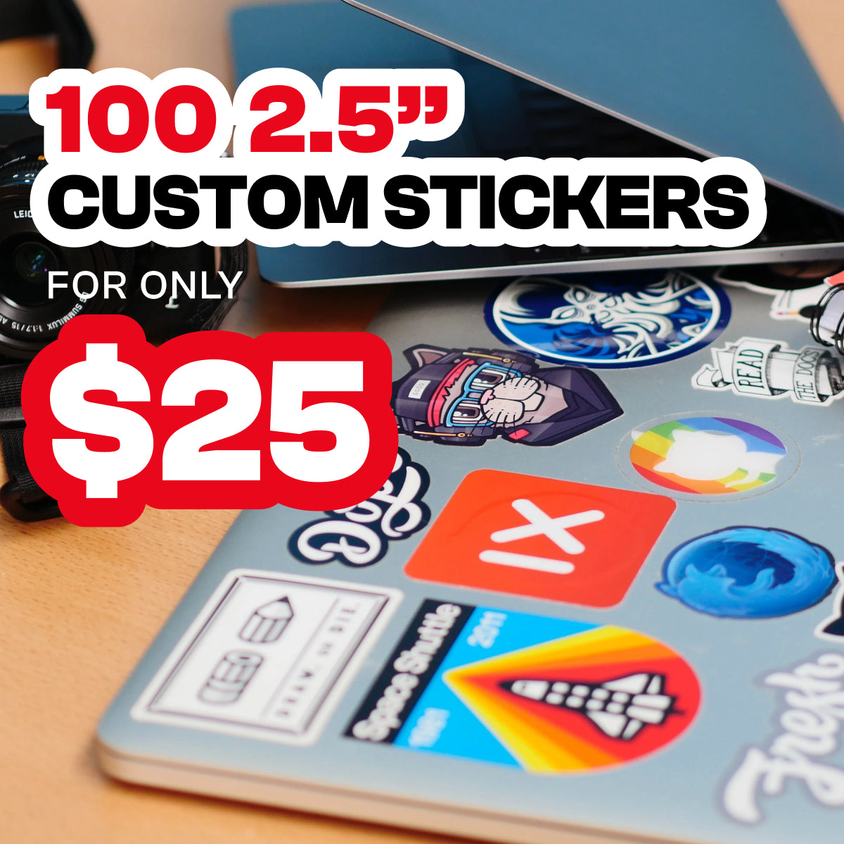Promo graphic reading 100 2.5" Custom Stickers for only $25 over a workspace scene. A laptop covered in assorted die cut vinyl stickers—featuring colorful logos, characters, icons, and a rainbow circle—sits beside a camera and notebook. The vibrant, mixed-art decals highlight waterproof custom sticker options for laptops and gear.