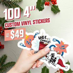 Hand holding several 4-inch custom vinyl stickers with festive cartoon designs, including a smiling ornament, a hot cocoa cup with steam labeled HOT CHOCO, a cheerful star, and a Santa hat character. Surrounded by holly leaves and red berries. On-image text reads 100 4