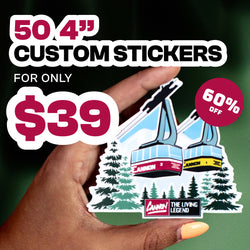 Promotional graphic advertising a discounted sticker offer. Text reads as 50 4-inch CUSTOM STICKERS, FOR ONLY $39, with a circular badge that reads as 60 percent OFF. Bold white and red text appears over a dark green background. A hand holds a detailed illustrated sticker showing ski gondolas labeled Cannon above evergreen trees, highlighting sharp print quality, clean die-cut edges, and custom vinyl sticker production.