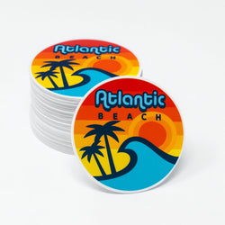 Stack of 'Atlantic Beach' circle stickers with a retro design featuring palm trees and waves on a white background.