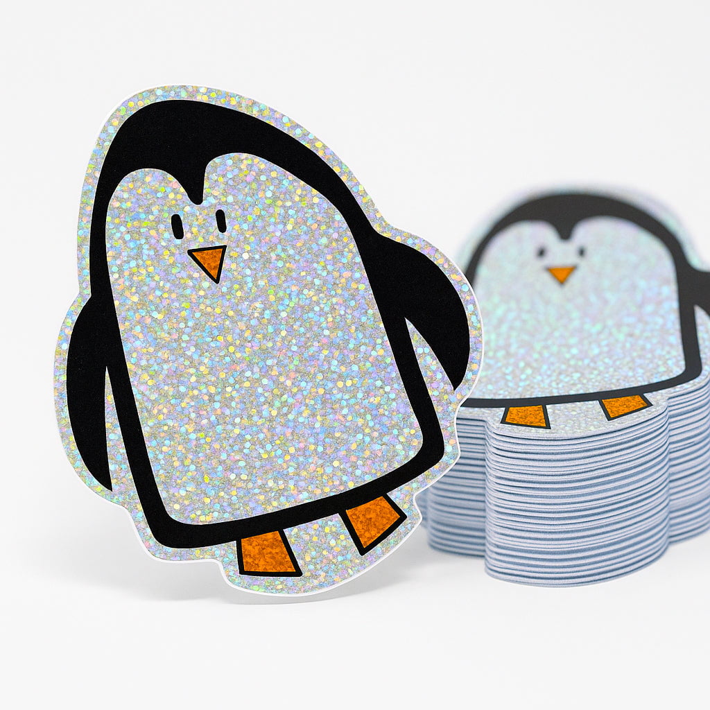 Holographic glitter penguin stickers on a white background