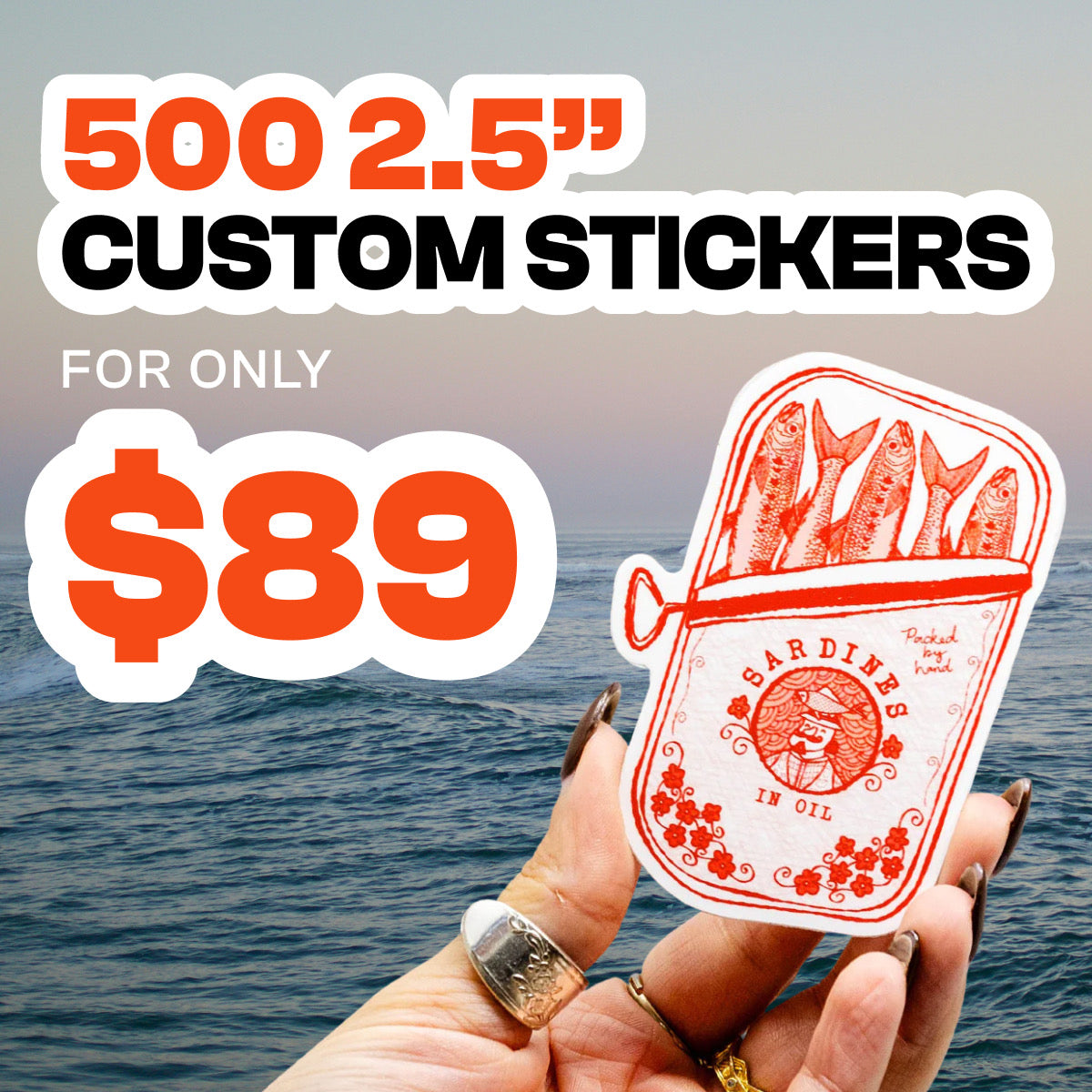 Hand holding a 2.5-inch custom vinyl sticker illustrated like a vintage sardine tin in bold red line art, showing fish packed in oil with floral accents and retro typography. Ocean waves and a soft sunrise backdrop highlight the waterproof aesthetic. On-image text reads 500 2.5” Custom Stickers for only $89, promoting durable die-cut decals.