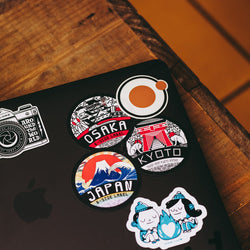 3 vinyl laptop stickers on a macbook latop