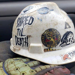 White hard hat with multiple helmet stickers