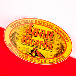 Yellow and red oval sticker with text fiddlehead brewing company Juan Ricardo Brewed with limes, agave and corn tortillas Mexican style lager
