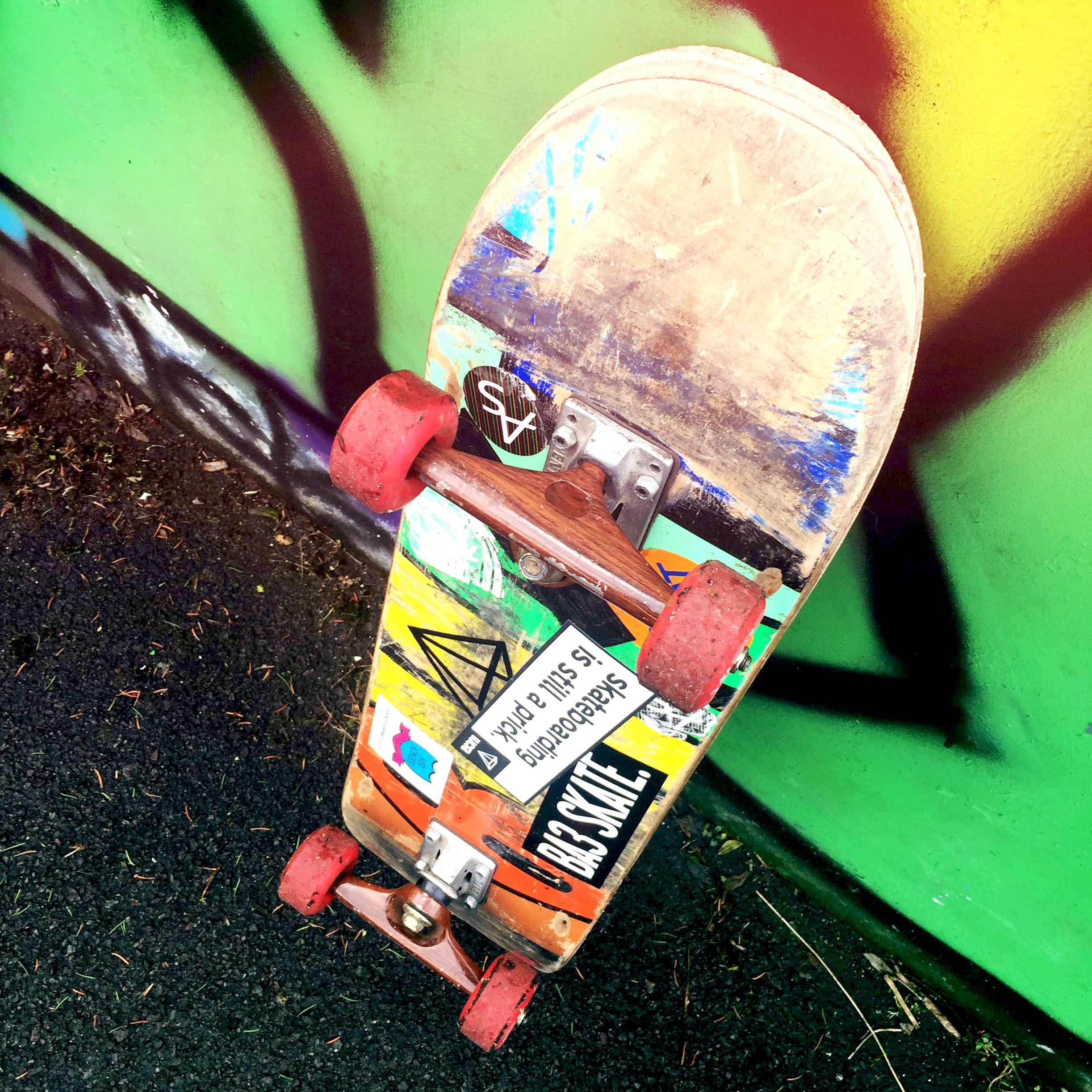 Worn skateboard with a couple skateboard sticker decals
